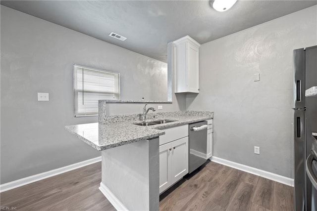 kitchen featuring white cabinetry, sink, stainless steel appliances, dark hardwood / wood-style floors, and kitchen peninsula