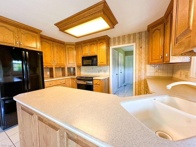 kitchen with sink, kitchen peninsula, decorative backsplash, light tile patterned floors, and black appliances