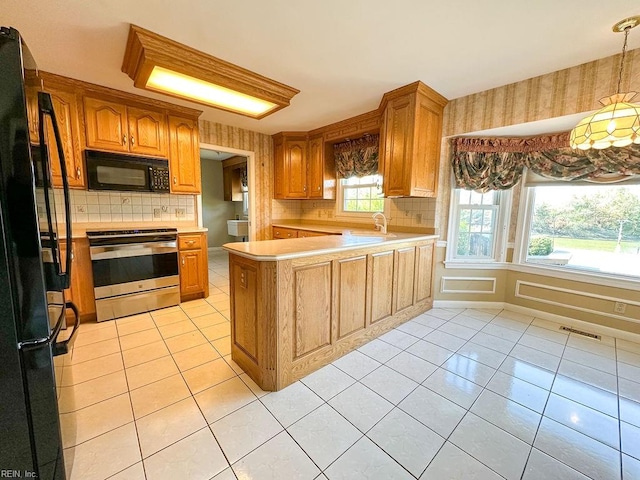 kitchen featuring decorative backsplash, light tile patterned floors, plenty of natural light, and black appliances