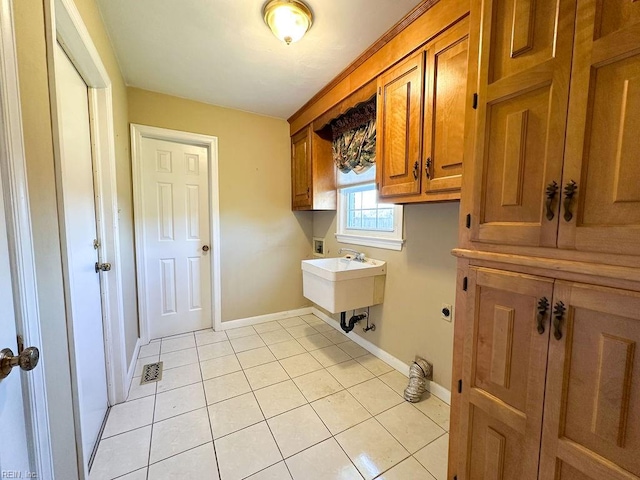 washroom with sink, washer hookup, cabinets, hookup for an electric dryer, and light tile patterned floors