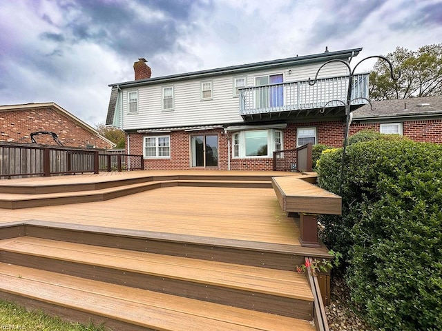 rear view of house with a balcony and a deck