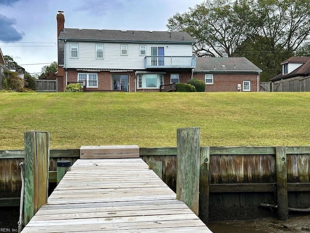 back of property with a lawn and a balcony