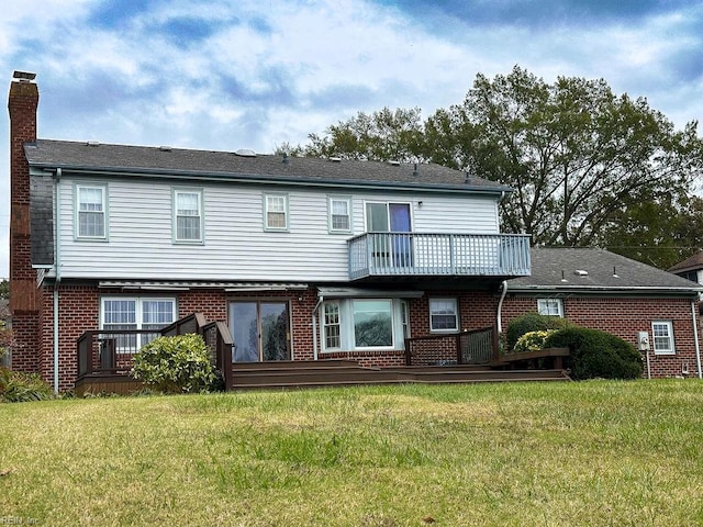 rear view of house with a lawn and a balcony