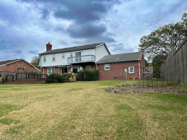 back of house featuring a lawn and a wooden deck