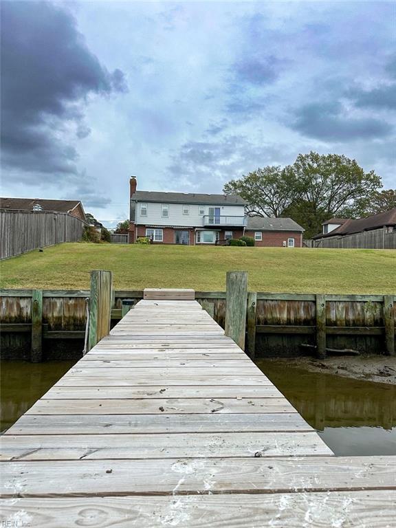 view of dock featuring a lawn and a water view