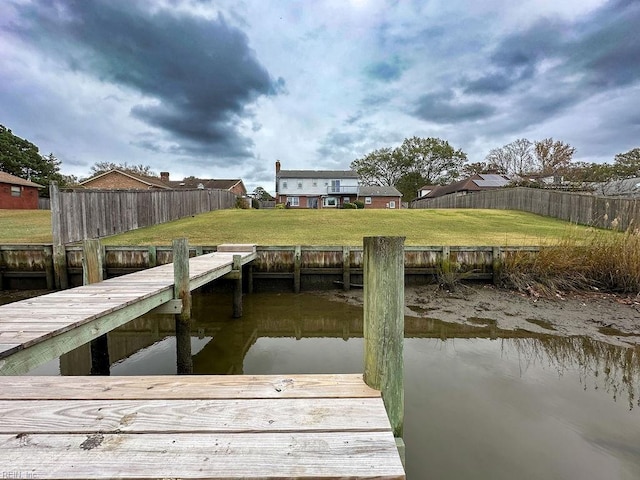 dock area with a water view and a yard