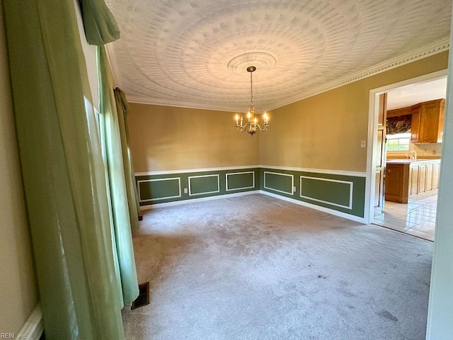 carpeted spare room featuring a chandelier, ornamental molding, and sink