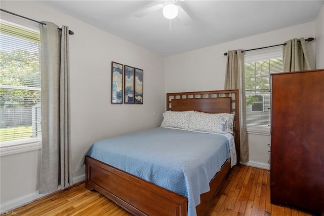 bedroom featuring multiple windows, ceiling fan, and light hardwood / wood-style flooring