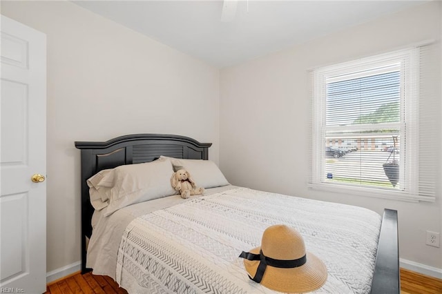 bedroom featuring hardwood / wood-style floors, ceiling fan, and multiple windows