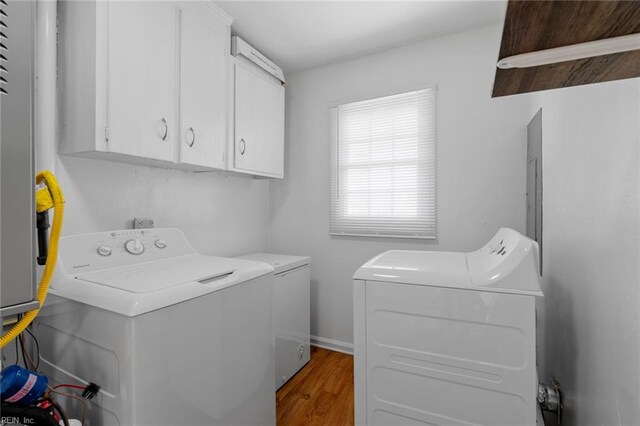 laundry area with cabinets, wood-type flooring, and independent washer and dryer