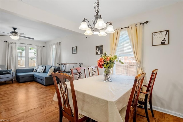 dining area featuring light hardwood / wood-style flooring and ceiling fan with notable chandelier