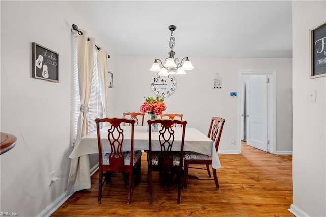 dining room with hardwood / wood-style floors and an inviting chandelier