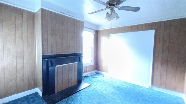 unfurnished living room with carpet, ceiling fan, and wood walls