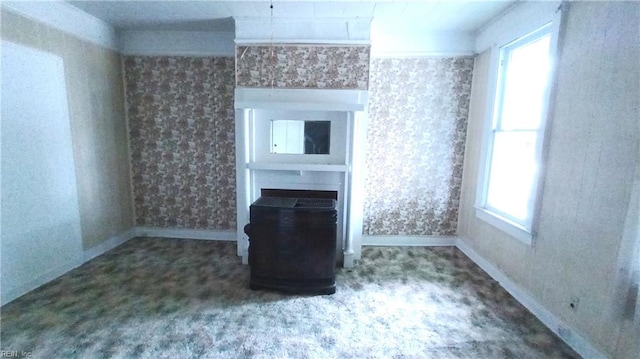 unfurnished living room with carpet floors and a healthy amount of sunlight