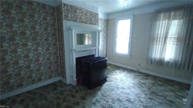 unfurnished living room featuring carpet flooring and plenty of natural light