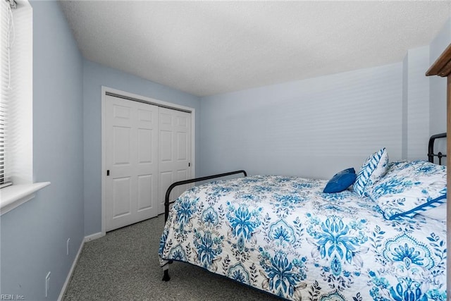 carpeted bedroom with a textured ceiling and a closet