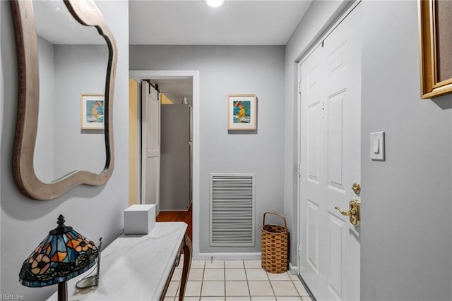 doorway featuring a barn door and light tile patterned floors