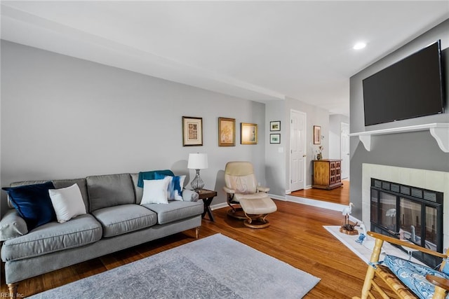 living room featuring hardwood / wood-style flooring and a tiled fireplace