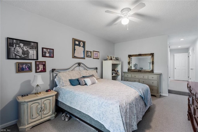 bedroom featuring a textured ceiling, ceiling fan, and light carpet