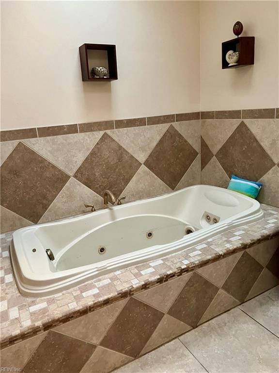 bathroom featuring tiled tub and tile patterned flooring