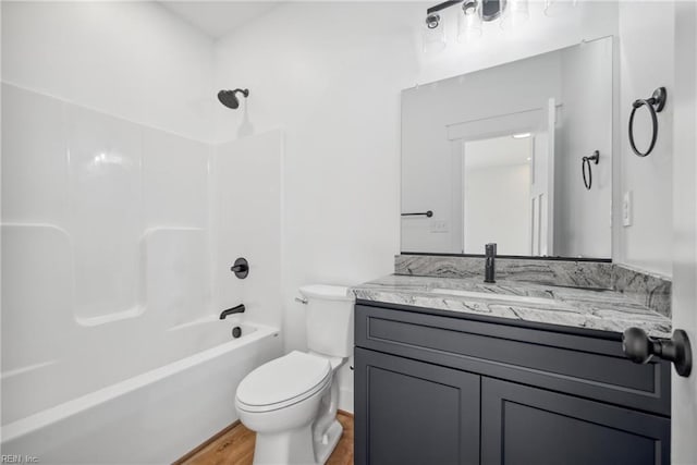 full bathroom with hardwood / wood-style floors, vanity,  shower combination, and toilet