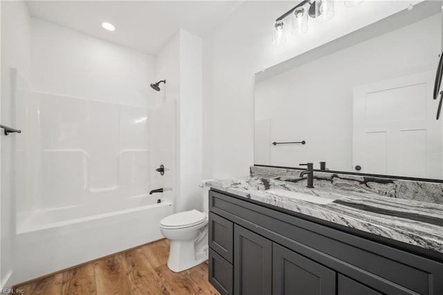 full bathroom featuring wood-type flooring, vanity, shower / bath combination, and toilet