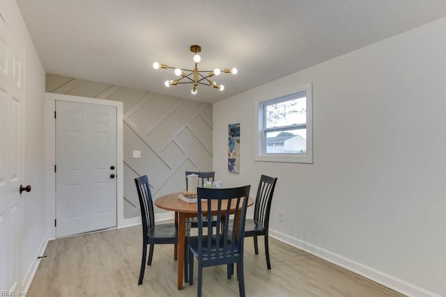 dining area featuring light hardwood / wood-style floors and an inviting chandelier