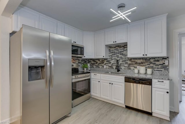 kitchen featuring white cabinetry, sink, appliances with stainless steel finishes, and light hardwood / wood-style flooring