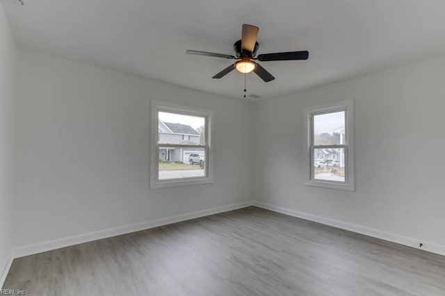 unfurnished room with ceiling fan, plenty of natural light, and hardwood / wood-style floors