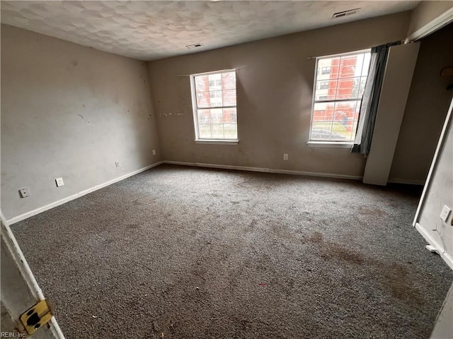 carpeted spare room with a textured ceiling