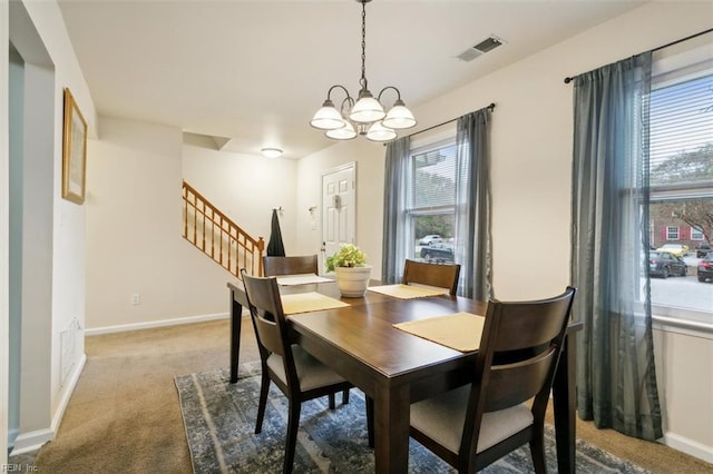 dining space featuring carpet flooring, a chandelier, and a healthy amount of sunlight