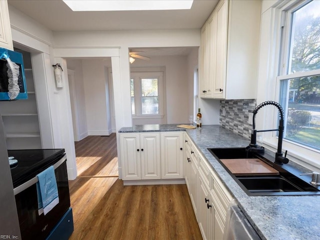 kitchen featuring white cabinetry, sink, ceiling fan, tasteful backsplash, and dark hardwood / wood-style flooring