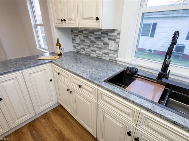 kitchen with dark hardwood / wood-style flooring, tasteful backsplash, and sink