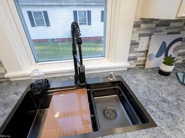 details featuring tasteful backsplash and sink