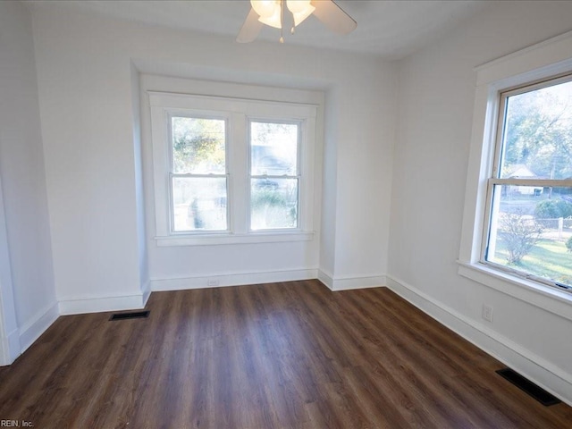 spare room with dark hardwood / wood-style floors, a wealth of natural light, and ceiling fan