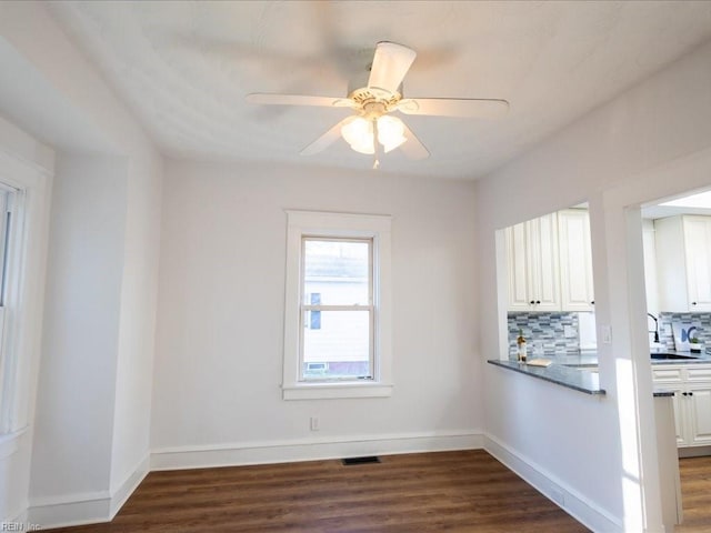 unfurnished dining area with dark hardwood / wood-style floors and ceiling fan