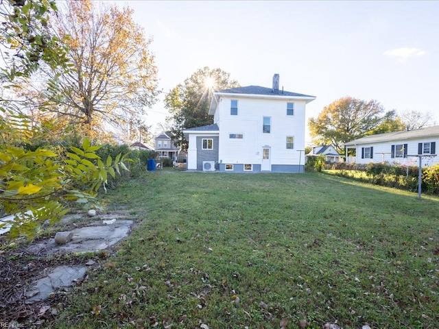 rear view of house featuring a yard