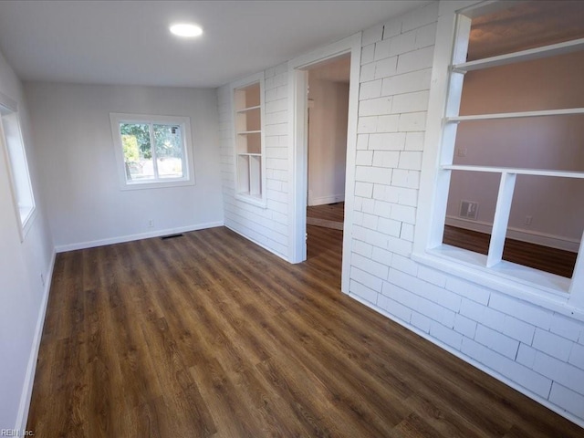 unfurnished room featuring dark hardwood / wood-style floors and built in features