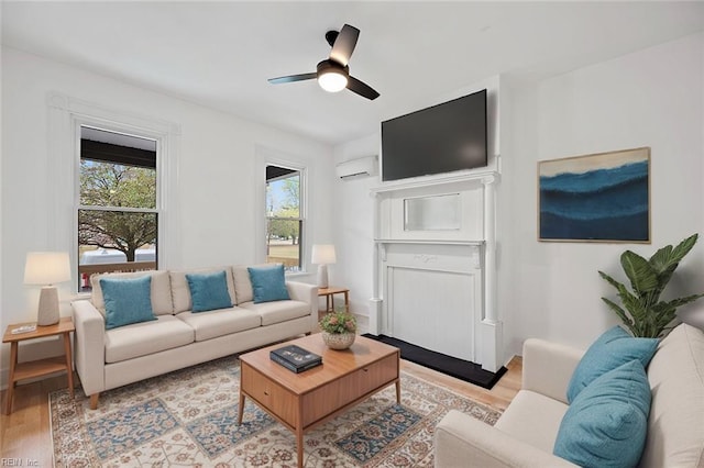 living room with ceiling fan, light hardwood / wood-style floors, a wealth of natural light, and a wall mounted AC