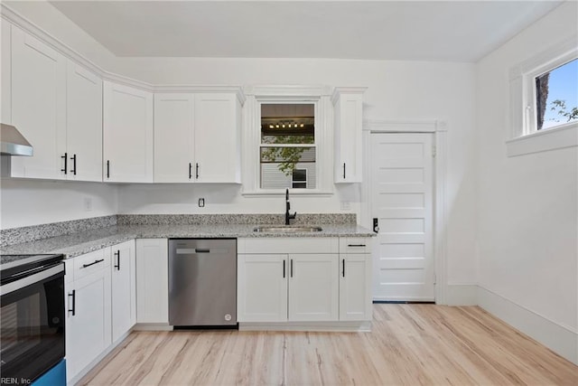 kitchen with sink, stainless steel appliances, light stone counters, white cabinets, and light wood-type flooring