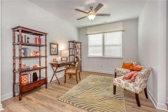 sitting room with ceiling fan and light wood-type flooring