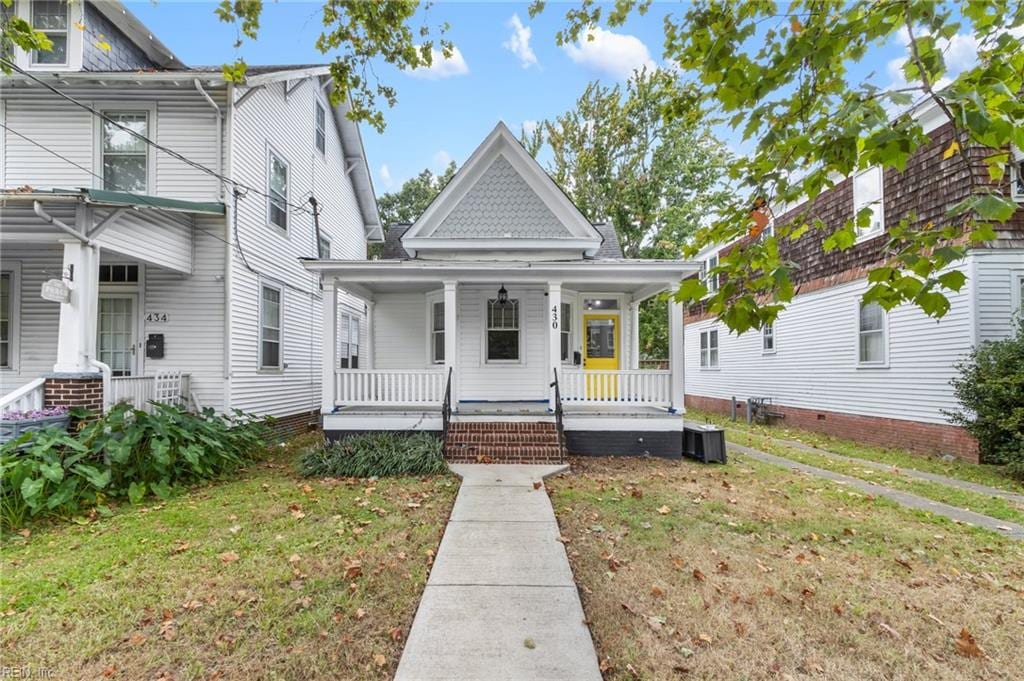 view of front facade featuring central AC unit, a porch, and a front yard