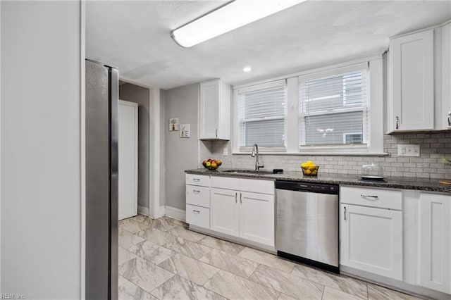 kitchen featuring dark stone counters, sink, white cabinets, and stainless steel appliances