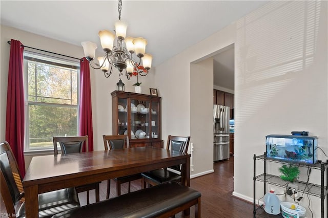 dining area featuring plenty of natural light, dark wood-type flooring, and a notable chandelier