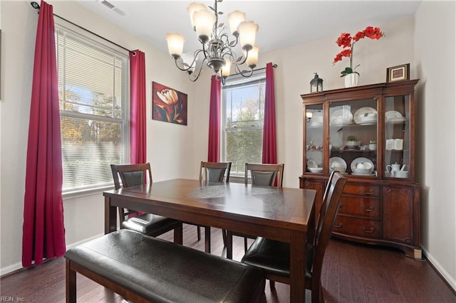 dining area with dark hardwood / wood-style flooring and a notable chandelier