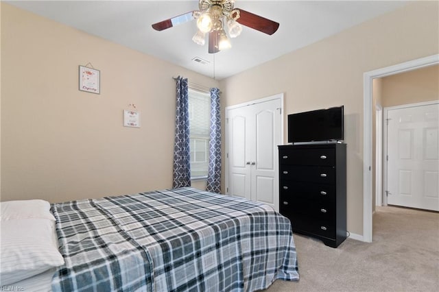 carpeted bedroom featuring ceiling fan and a closet