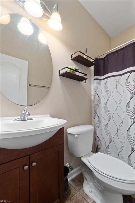 bathroom featuring tile patterned floors, vanity, and toilet