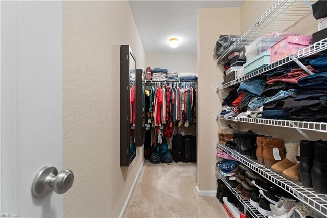 walk in closet featuring light carpet