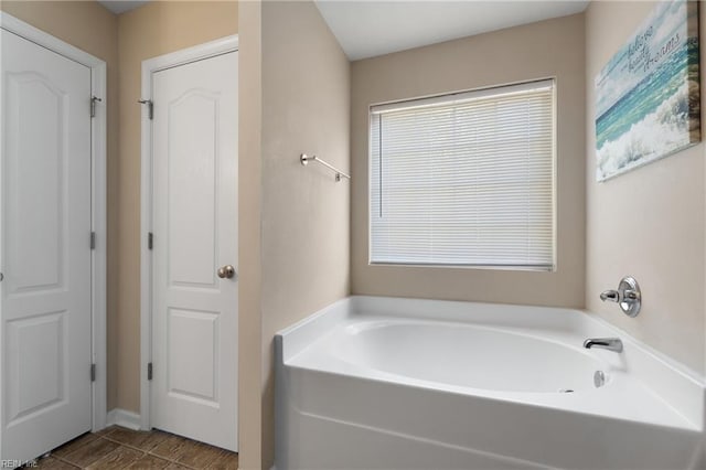 bathroom with plenty of natural light and a bath