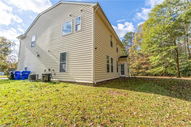 back of house with a lawn and central air condition unit